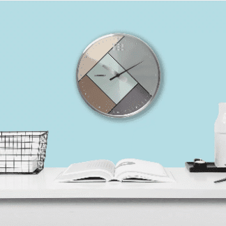 Modern geometric wall clock above a minimalist desk setup.