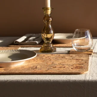 Elegant dining table set with a candle and glassware.