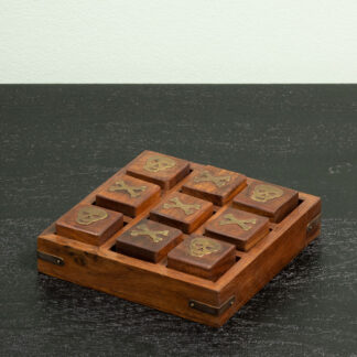 A wooden tray holding nine pieces of chocolate on a dark surface.