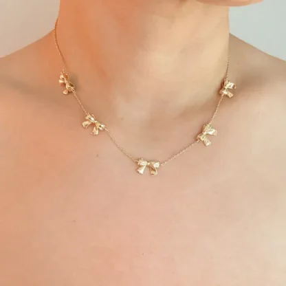 Delicate gold necklace with small flower charms around the neck.