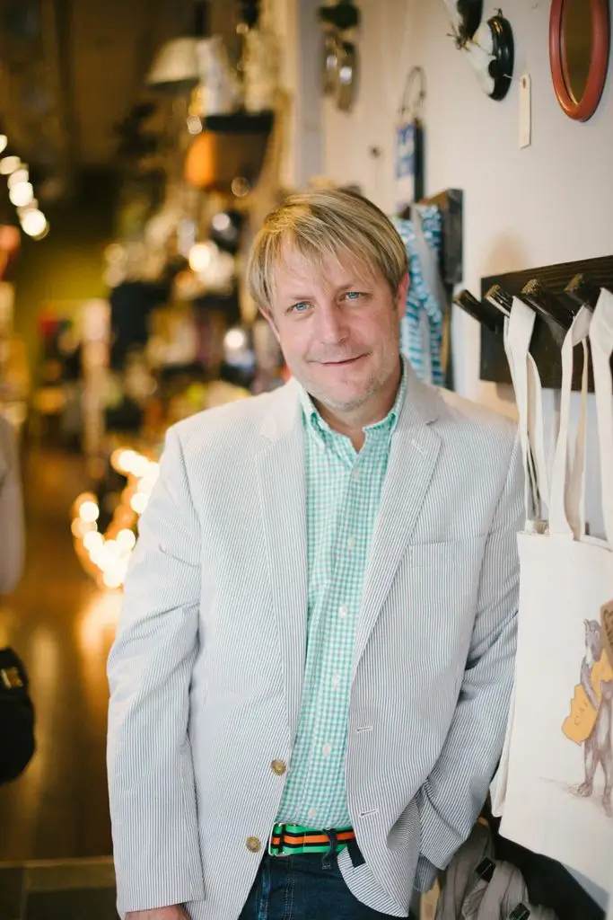 Man in store wearing a light suit.
